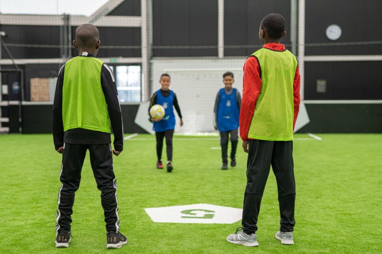 Jeunes joueurs en chasuble sur un terrain de foot à 5
