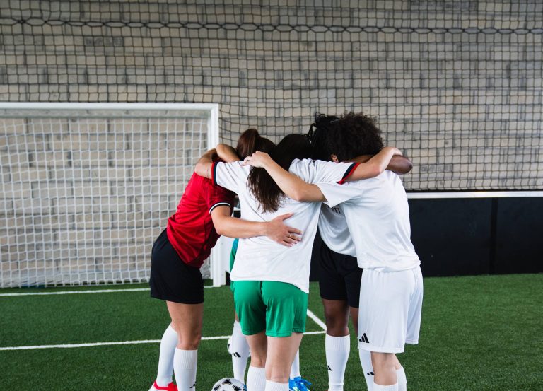 Équipe réunie en cercle sur un terrain de foot à 5