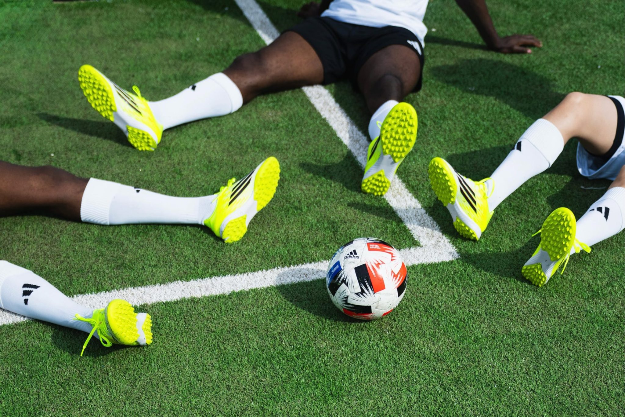 Joueurs de foot assis sur le gazon autour d’un ballon