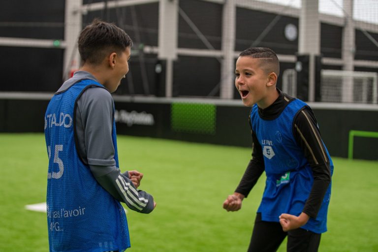 Deux enfants en chasuble sur un terrain de foot
