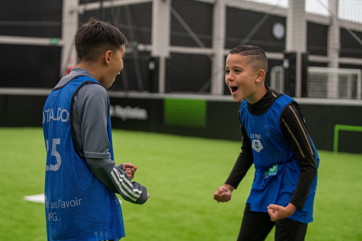 Deux enfants en chasuble sur un terrain de foot