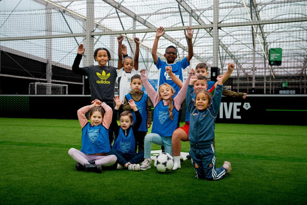 Enfants qui sautent de joie sur un terrain de foot