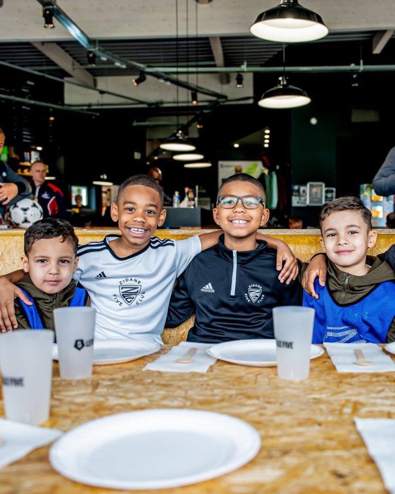 Enfants attablés pour un goûter, en maillots de foot