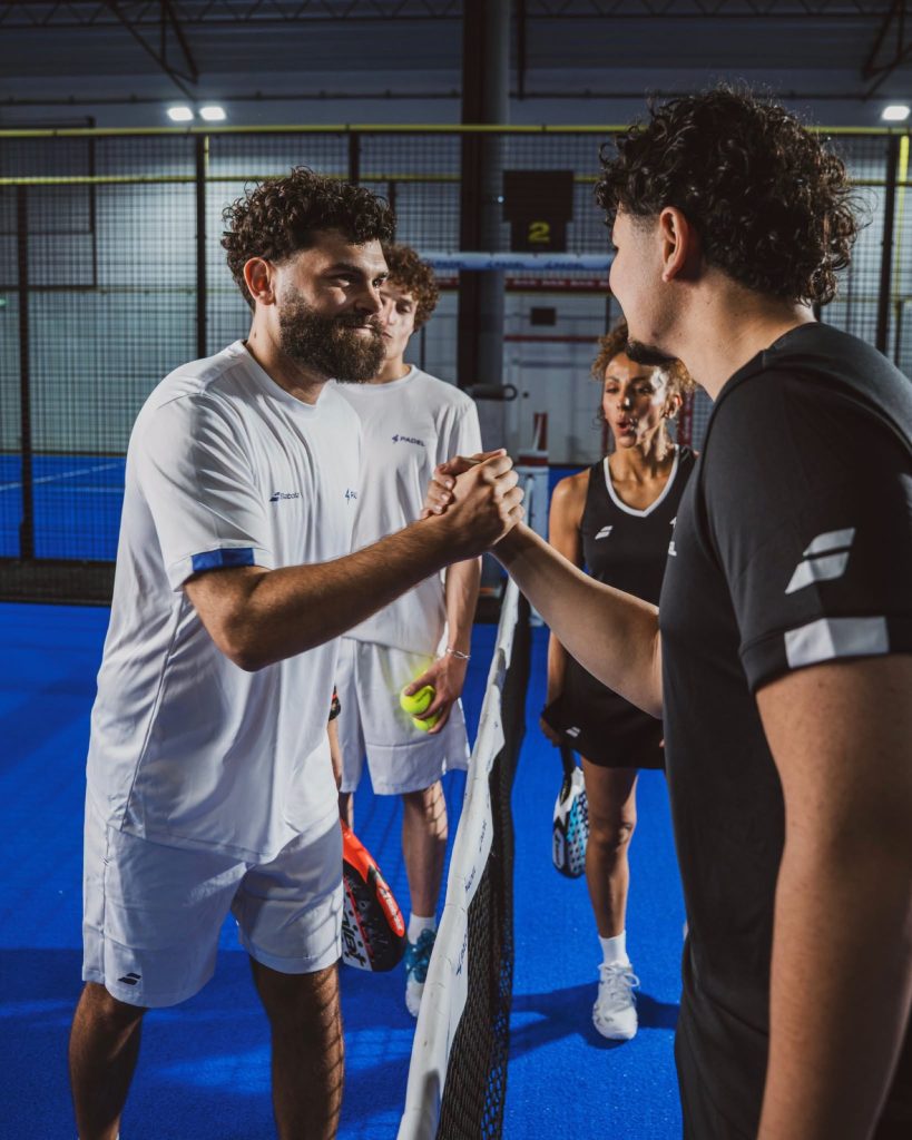 Joueurs de padel qui se serrent la main au filet