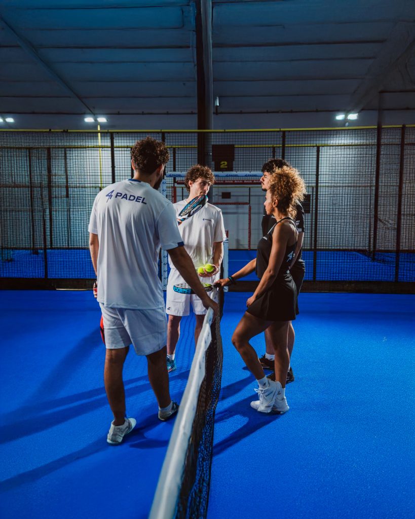 Groupe de joueurs au filet d’une piste de padel