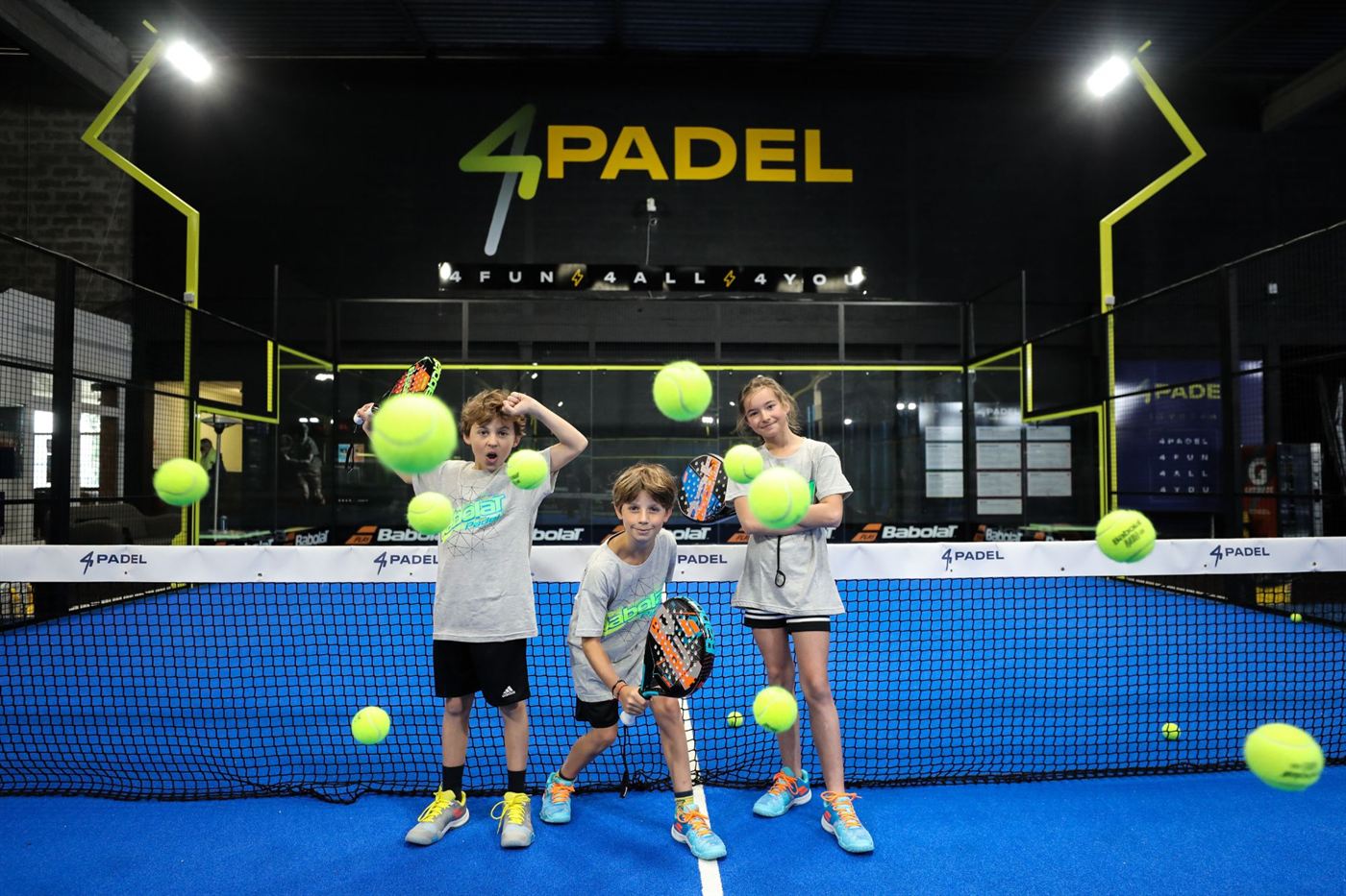 Enfants avec leurs raquettes sur une piste 4PADEL