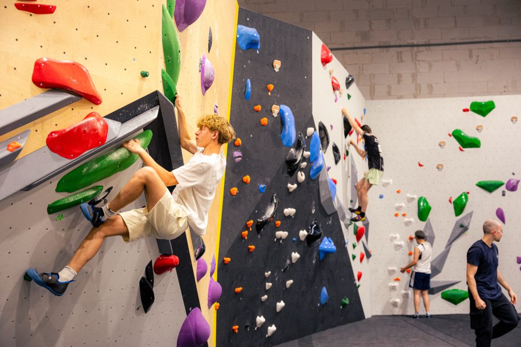 Grimpeur sur un mur de bloc Vertical’Art